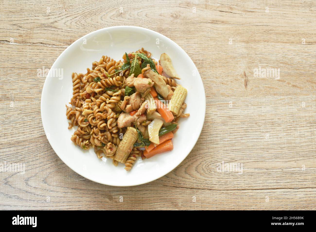 spicy stir fried fusilli pasta with chicken and vegetable in chili Thai