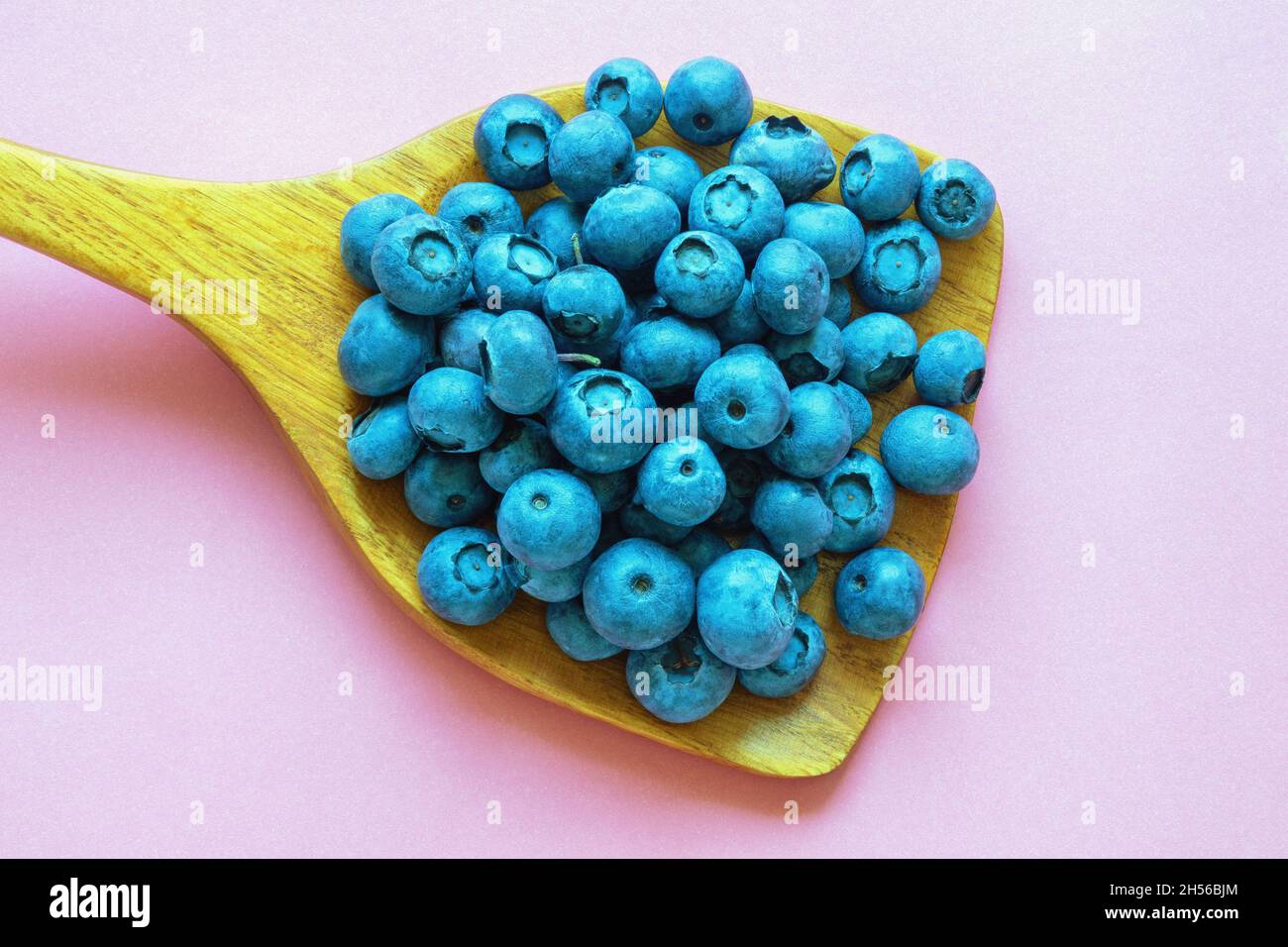 Bog whortleberries in wooden spoon. Free space for text Stock Photo