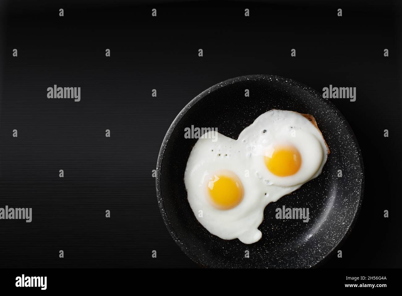 Fried eggs in skillet. Copy space for your text. Flat lay. Stock Photo