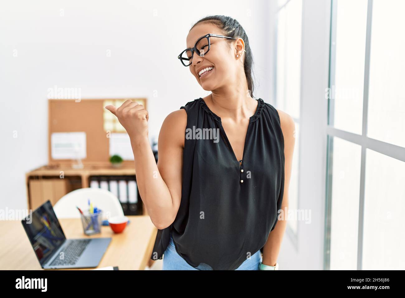 Young hispanic business woman working at the office smiling with happy ...