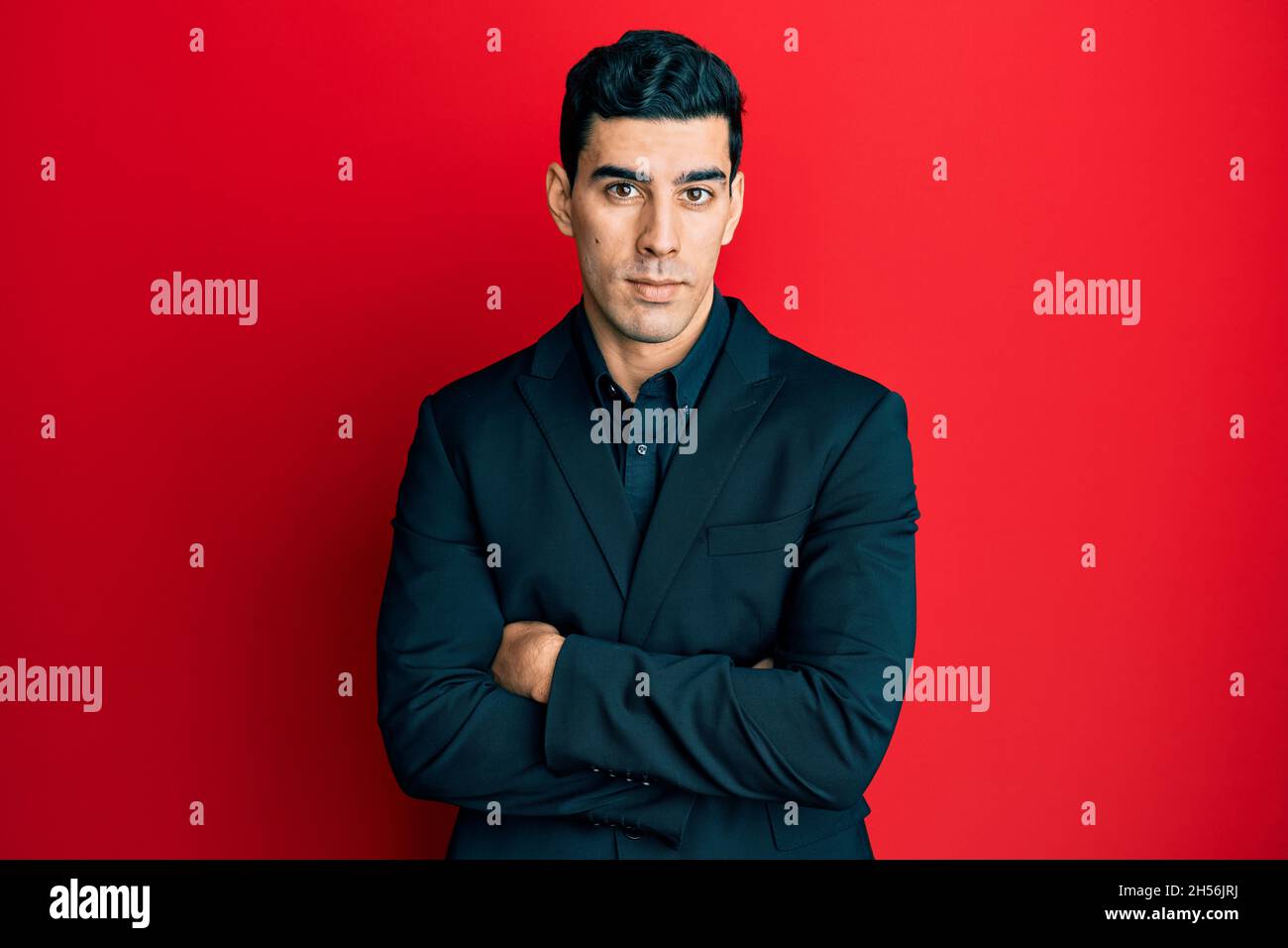 Handsome hispanic business man with arms crossed gesture relaxed with ...