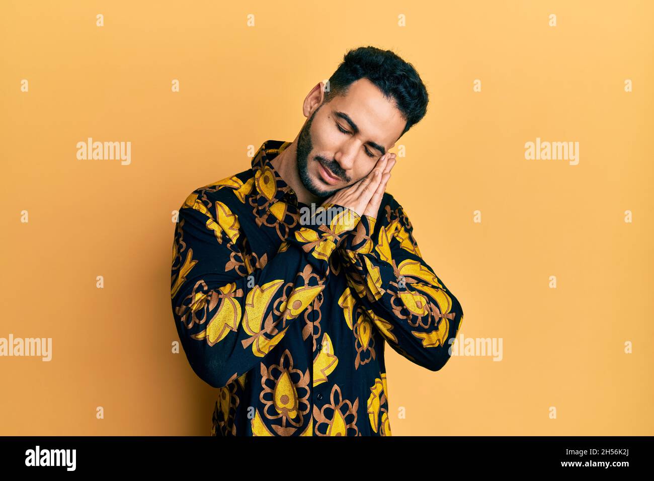Young hispanic man wearing casual shirt sleeping tired dreaming and ...