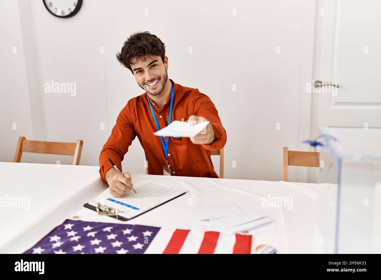 Young hispanic man smiling confident holding vote and writing on checklist at electoral college Stock Photo