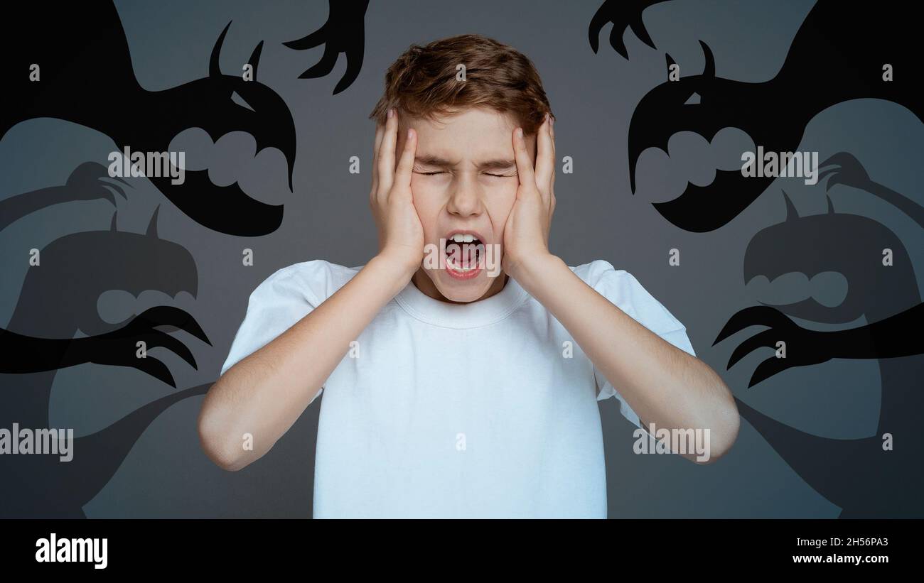 Scared little boy closing eyes, covering ears and screaming in panic, fighting fantasy monsters and inner fears, collage Stock Photo