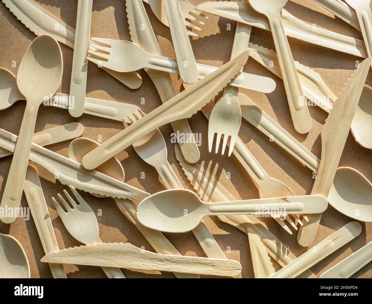 eco friendly disposable kitchenware utensils on craft paper background. Wooden forks, knives and spoons. Ecology, zero waste concept. top view. flat Stock Photo