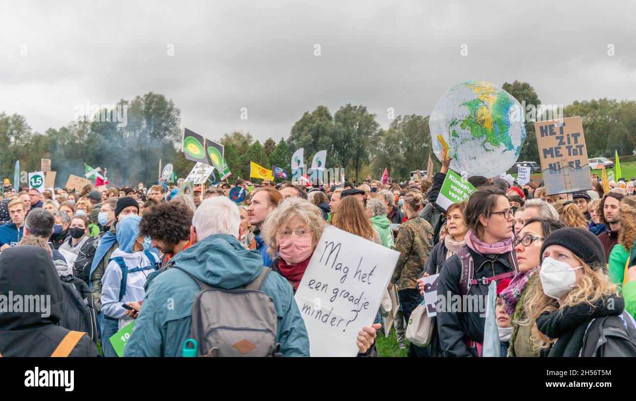 Amsterdam, Netherlands, November 06, 2021. View over the crowd at the Westerpark end happening. A big globe ball is held high, and a woman holds a sign: 'can it be a degree less'. An estimated 40.000 people participated in the Climat March, organized by the Climate Crisis Coalition, a collaboration of 11 organizations. Credit: Steppeland/Alamy Live News Stock Photo