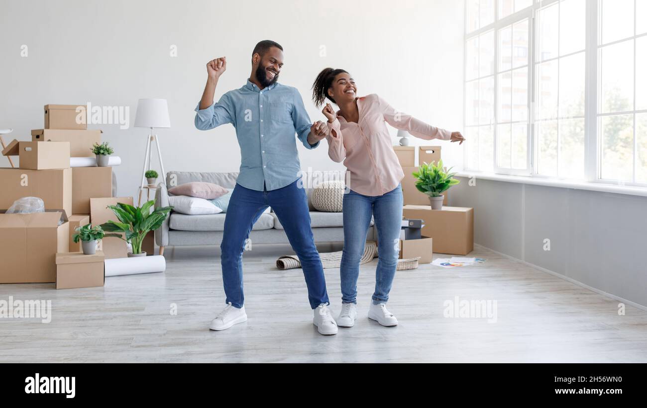 Happy millennial african american husband and wife dancing in new ...