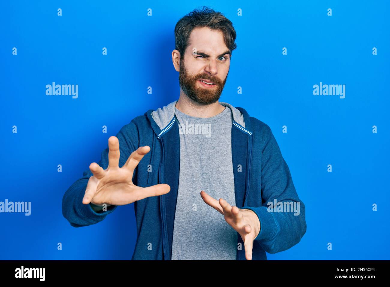 Caucasian man with beard wearing casual sweatshirt disgusted expression ...