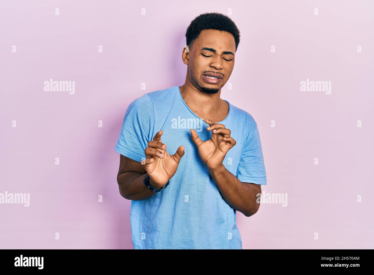 Young african american man wearing casual blue t shirt disgusted ...