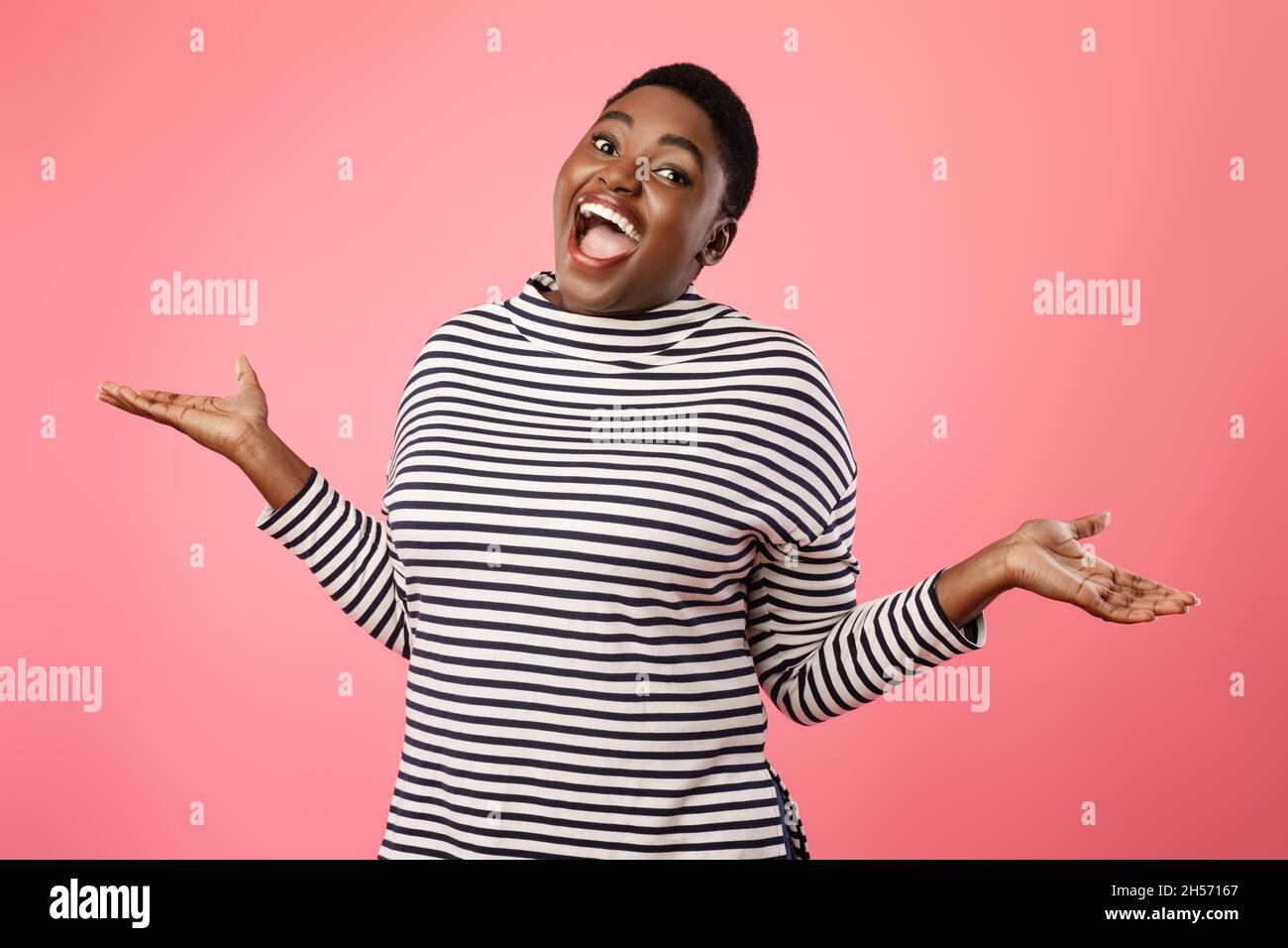 Cheerful Plump African American Lady Shrugging Shoulders Over Pink Background Stock Photo