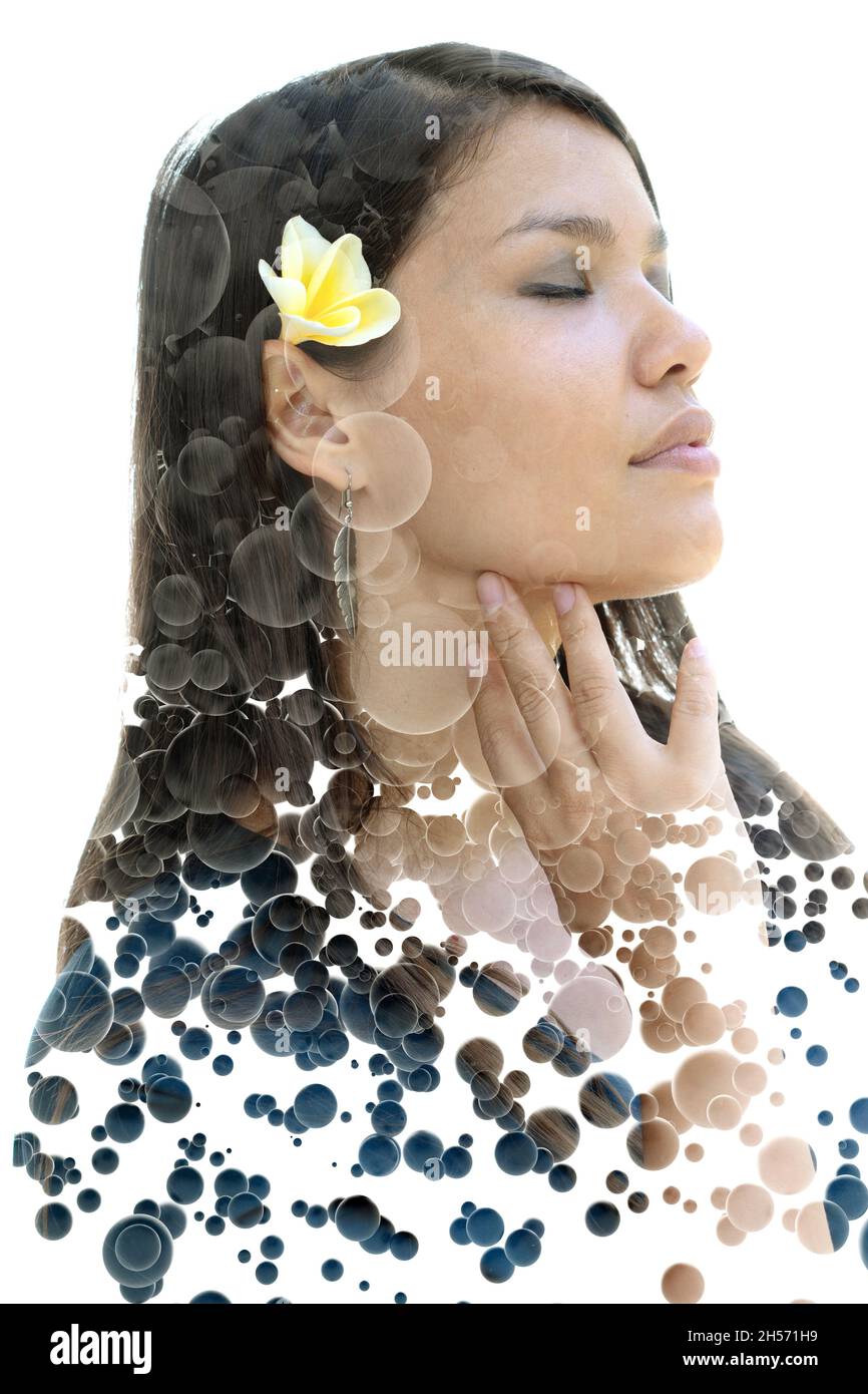 A portrait of a woman with flower in hair combined with floating 3d spheres in a double exposure technique Stock Photo