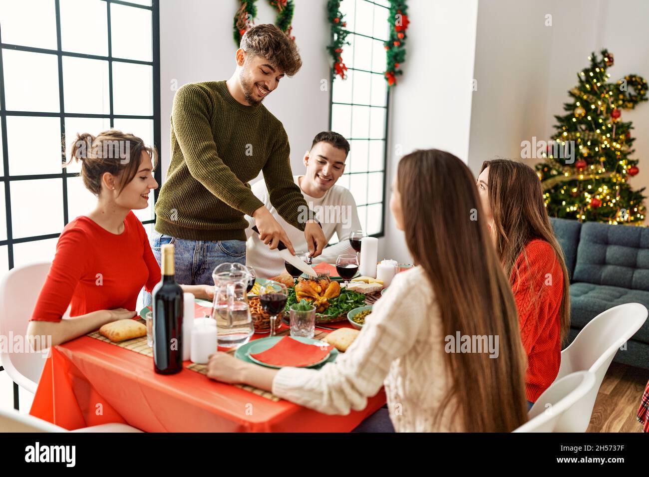 Group of young people smiling happy having christmas dinner, Man