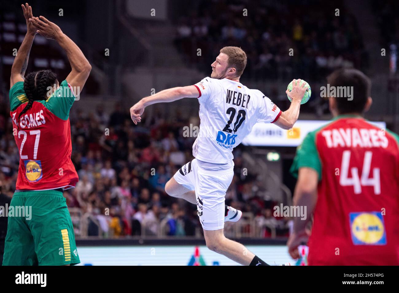 07 November 2021, North Rhine-Westphalia, Duesseldorf: Handball: International match, Germany - Portugal, ISS Dome. Germany's Philipp Weber (M) throws at goal. On the left Portugal's Andre Gomes, on the right Francisco Tavares. Photo: Marius Becker/dpa Stock Photo