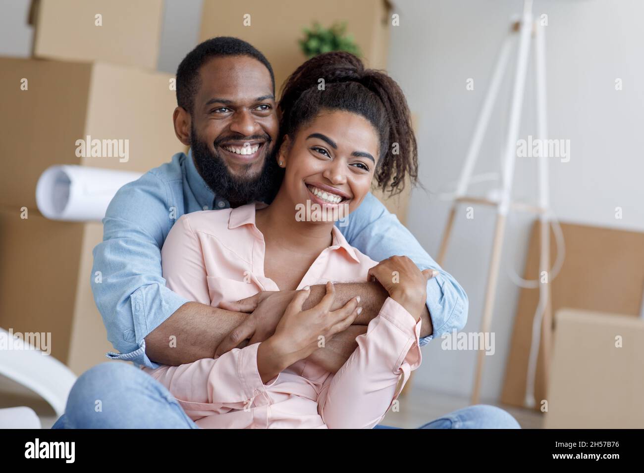Satisfied young african american husband and wife, hugging, take a ...