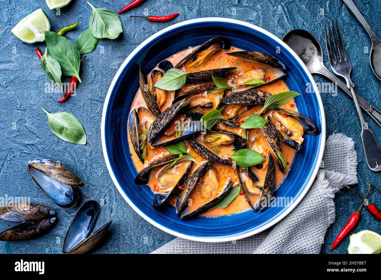 Delicious blue mussels in a spicy thai red curry sauce. Stock Photo