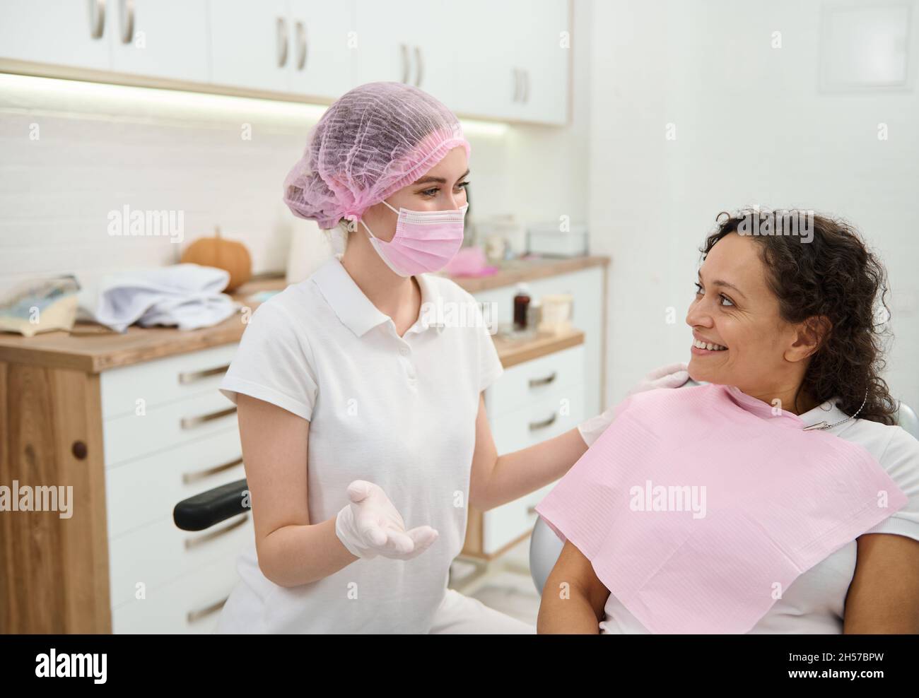 Dentist hygienist, dental assistant wearing pink medical mask and