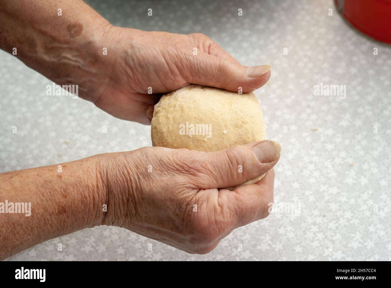 Elderly woman kneading dough with her hands Stock Photo