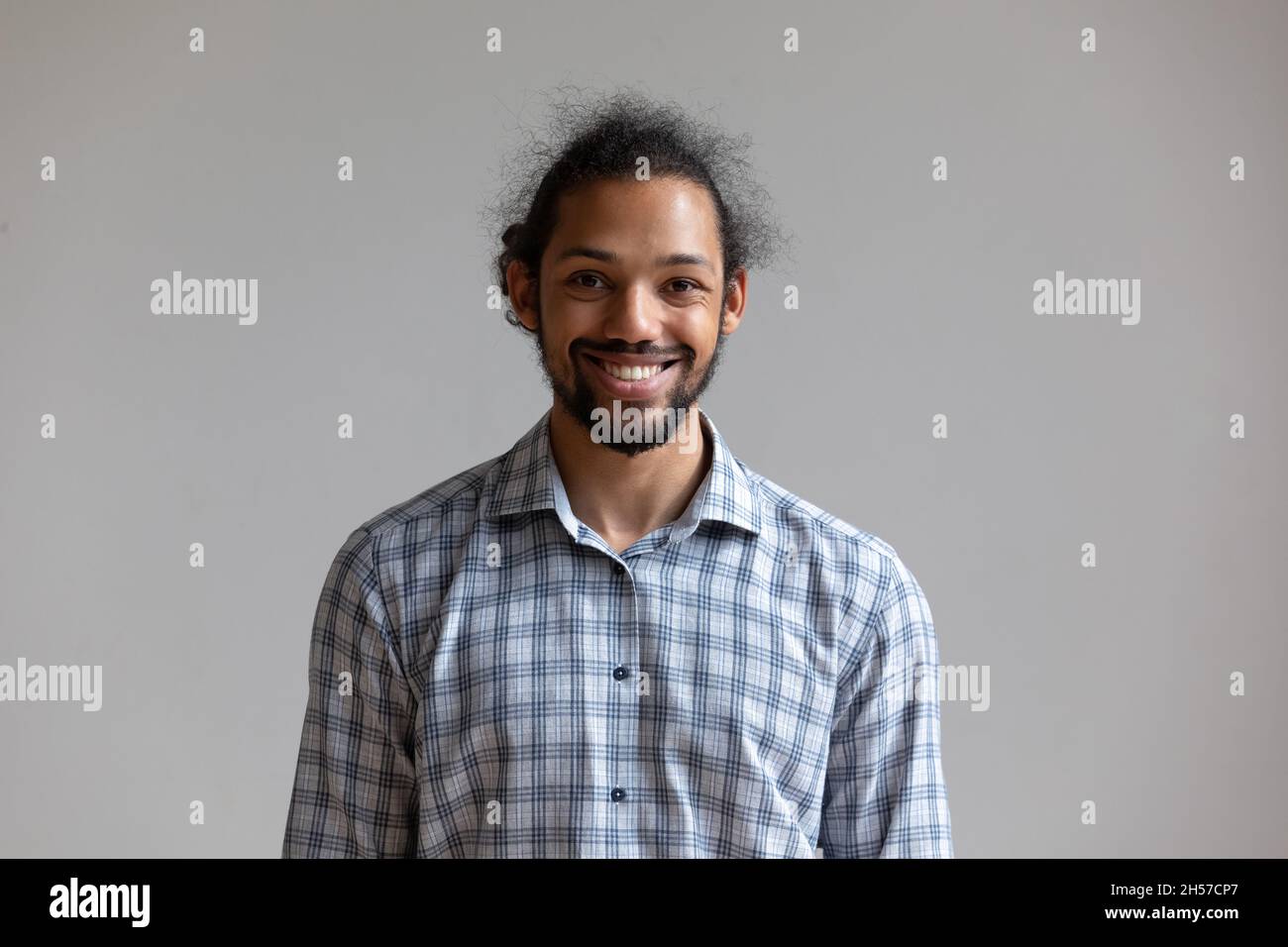 Happy millennial African American man standing isolated by white wall Stock Photo