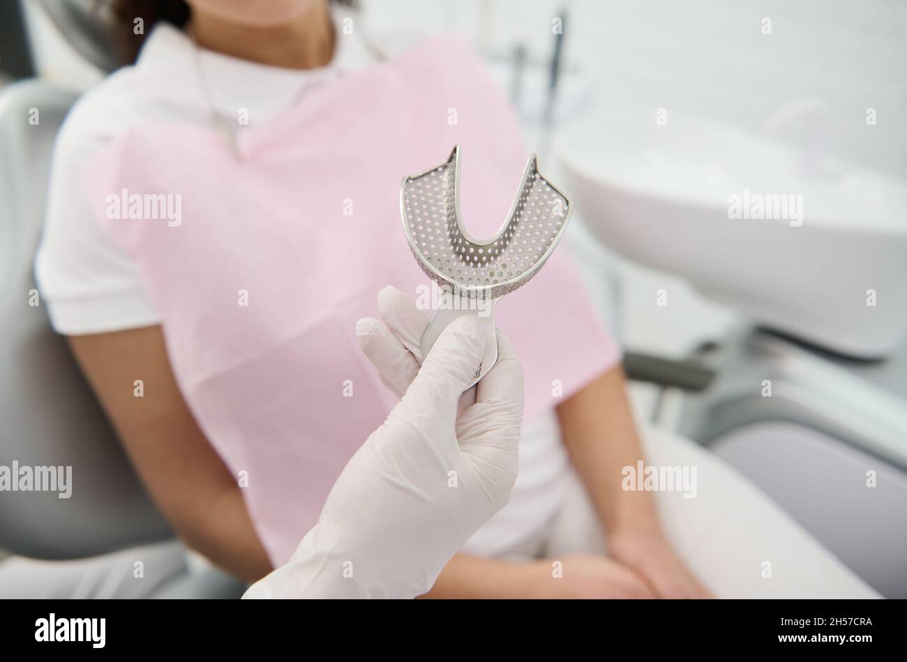 Closeup of a dentist's hand holding Dental mold dentists teeth ceramic