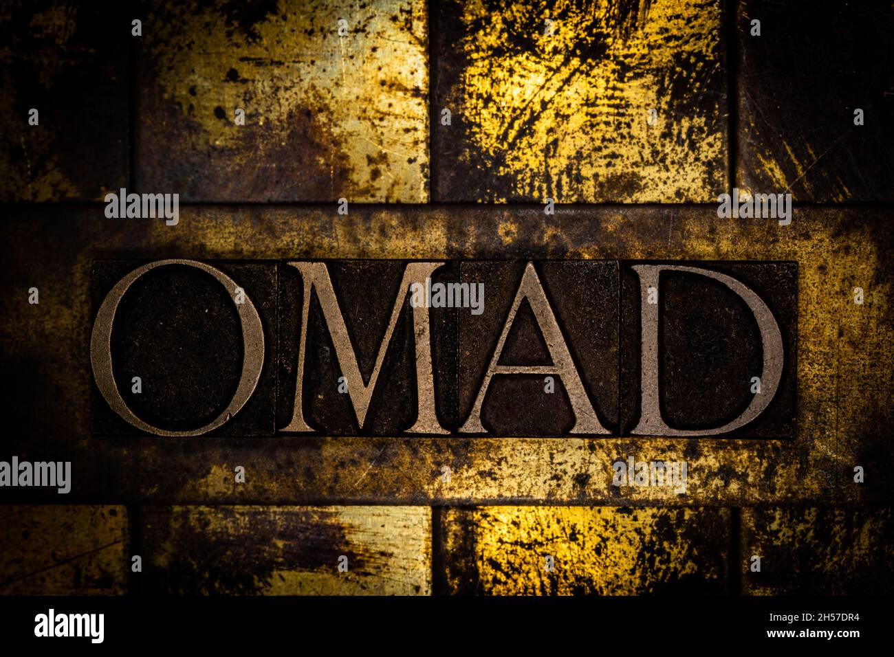 OMAD text on textured grunge copper and vintage gold background Stock Photo