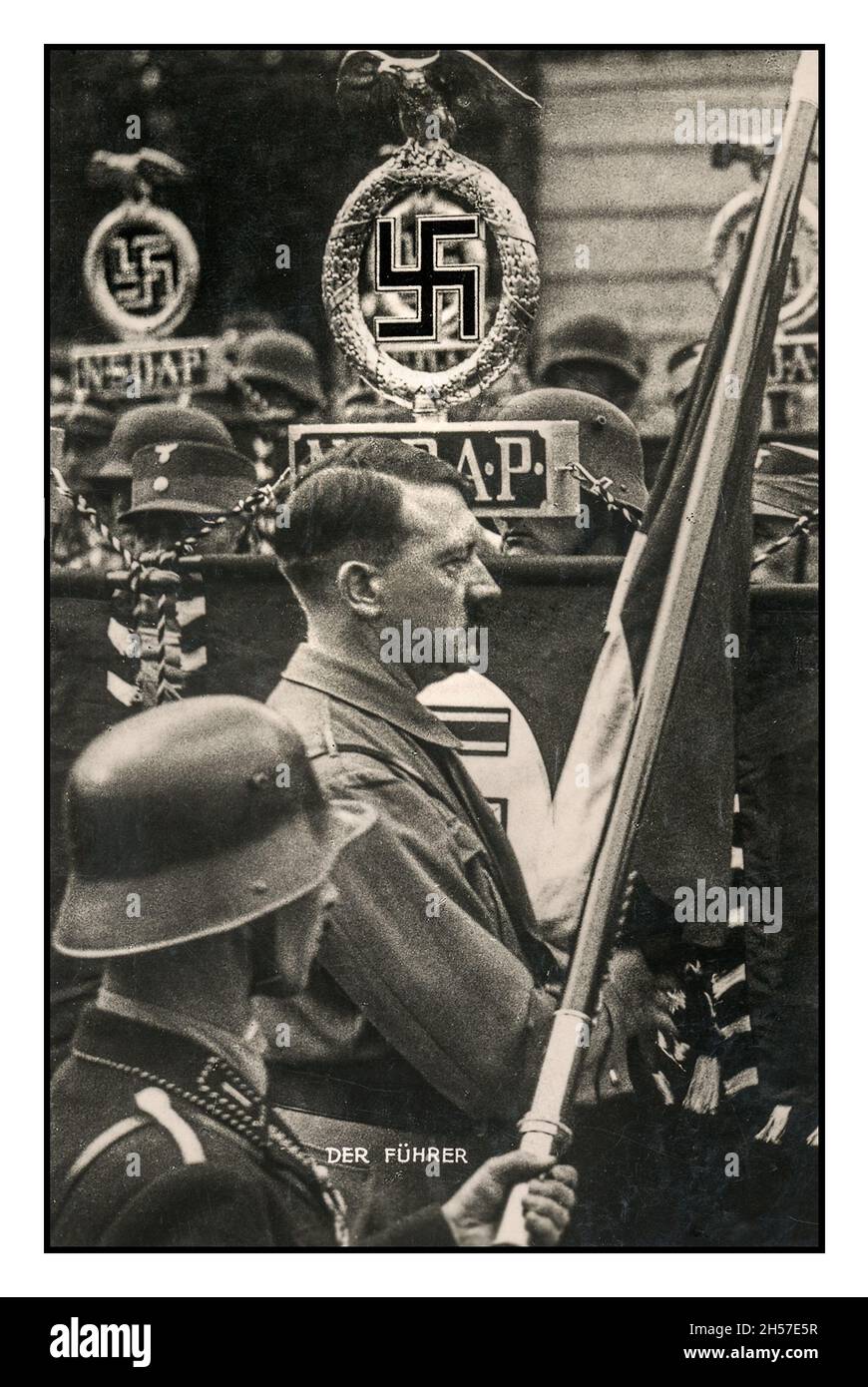 1930s Propaganda Poster card of Adolf Hitler titled 'Der Fuhrer' at an NSDAP Rally in Germany with ceremonial banners and flags with the swastika emblem symbol Stock Photo