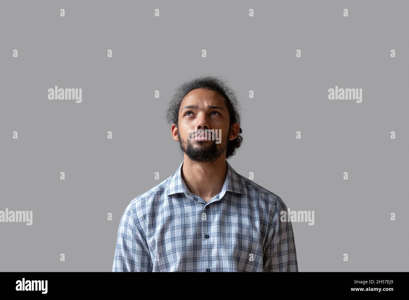 Serious young guy in casual standing isolated at grey background Stock Photo