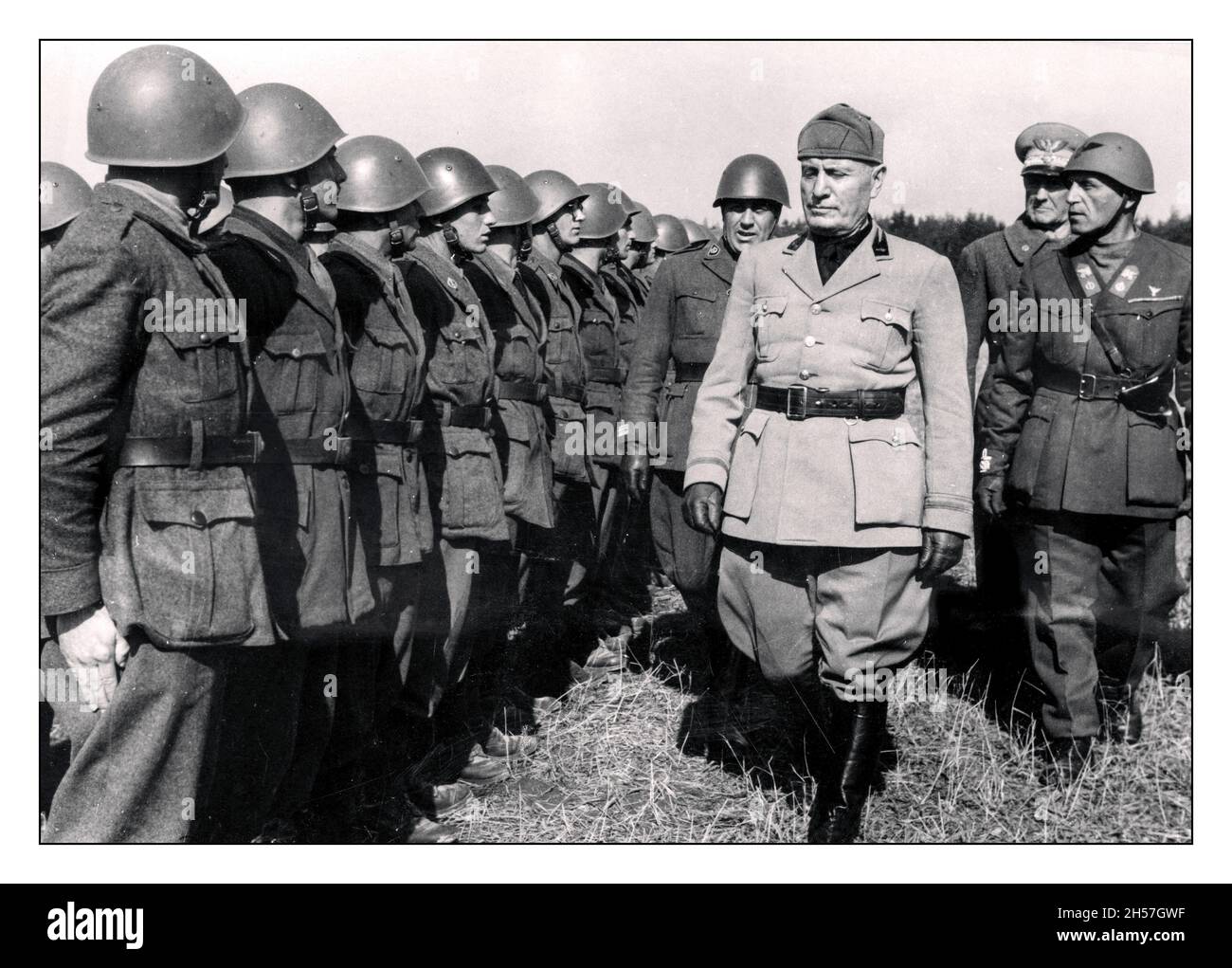 BENITO MUSSOLINI REVIEWING HIS TROOPS (1883-1945)  Italian dictator and leader of the Fascist movement and part of the WW2 Axis,  'EL DUCE'  In his military uniform with his Generals inspecting a line of Italian troops during World War II 1942 Facist Propaganda image Stock Photo