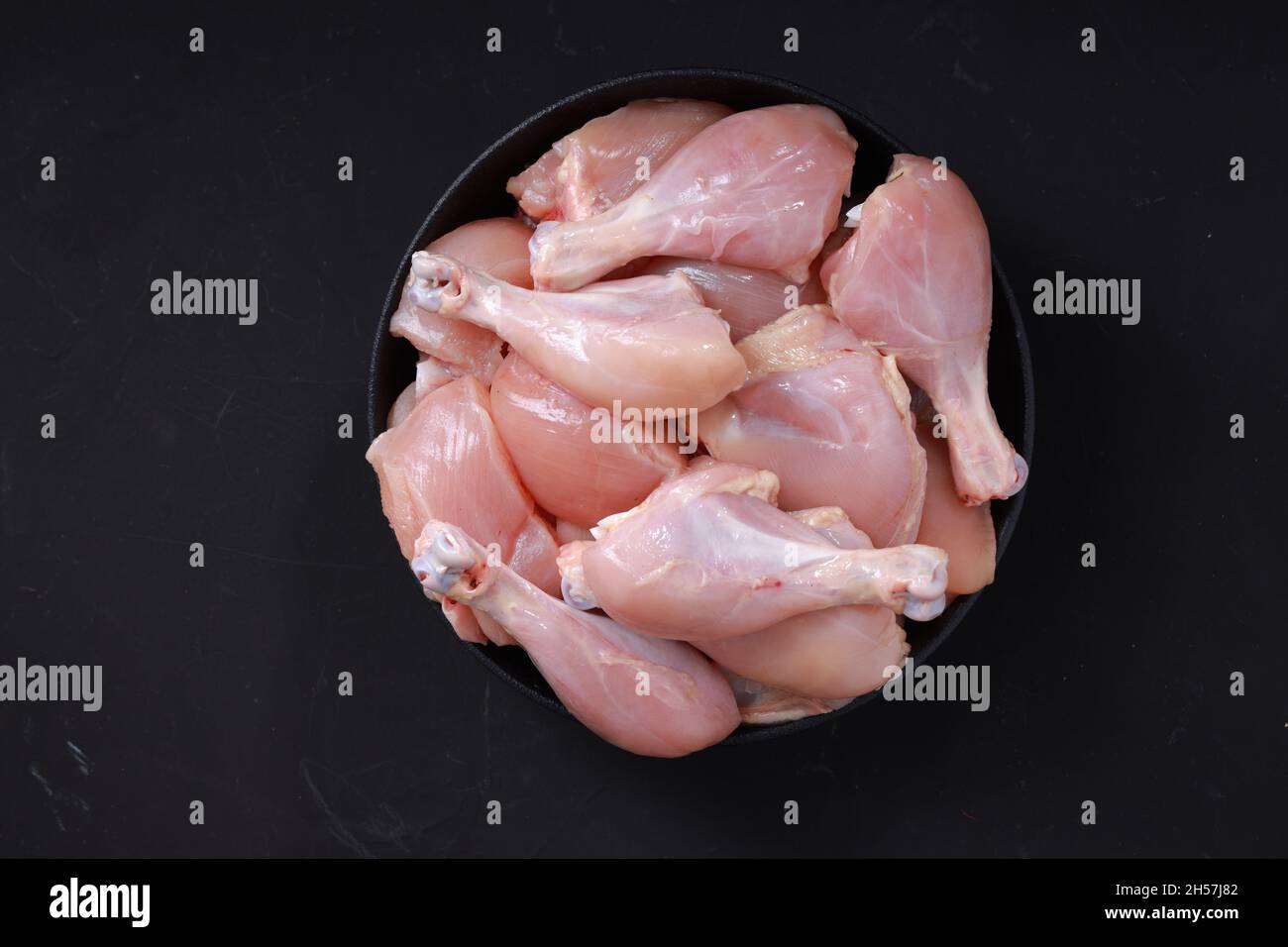 Raw chicken biriyani cut without skin arranged on black container , top view. Stock Photo