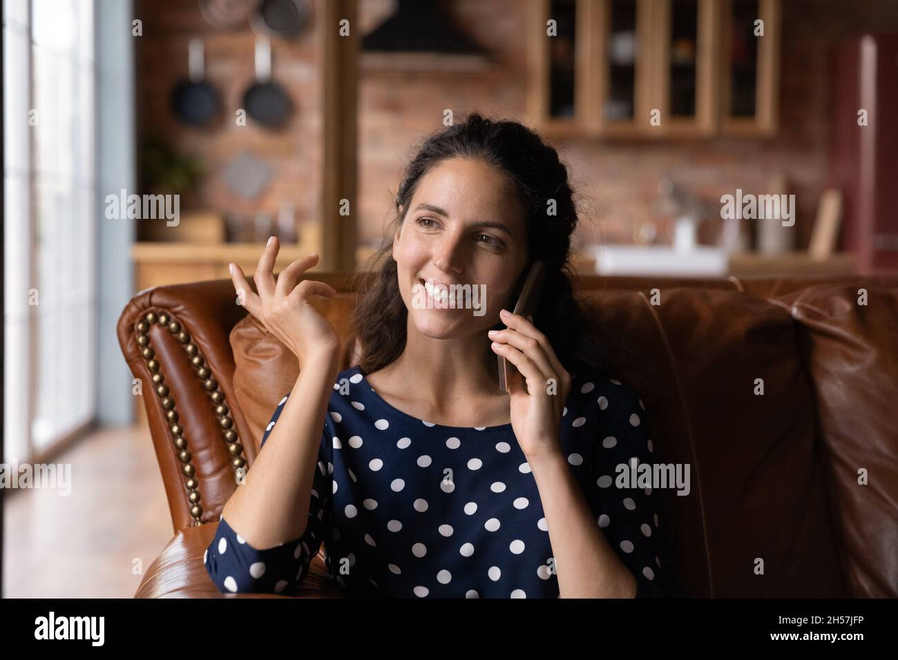 Young latin female having nice phone talk gossip with friend Stock Photo
