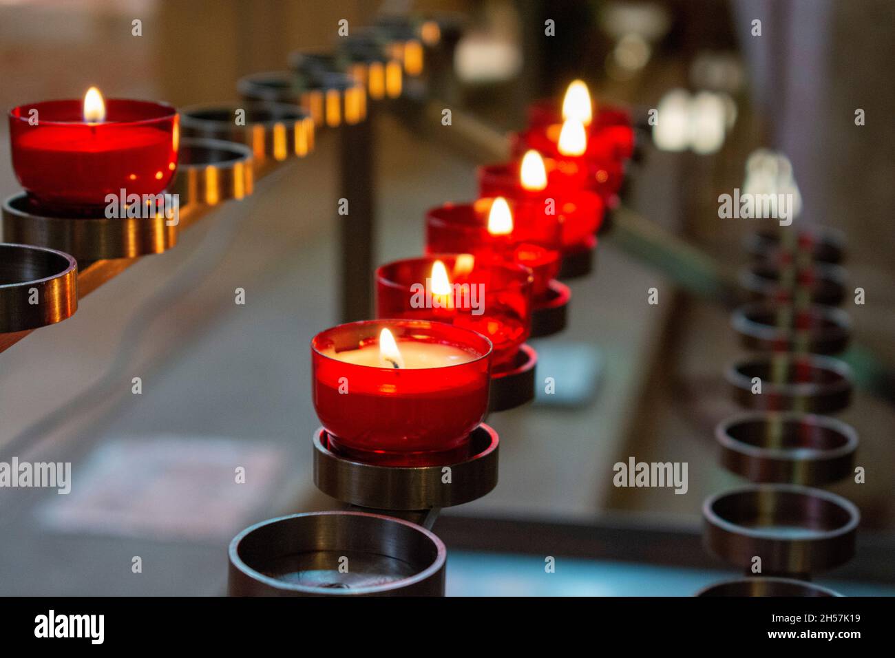 Burning red prayer candles inside a catholic church on a candle