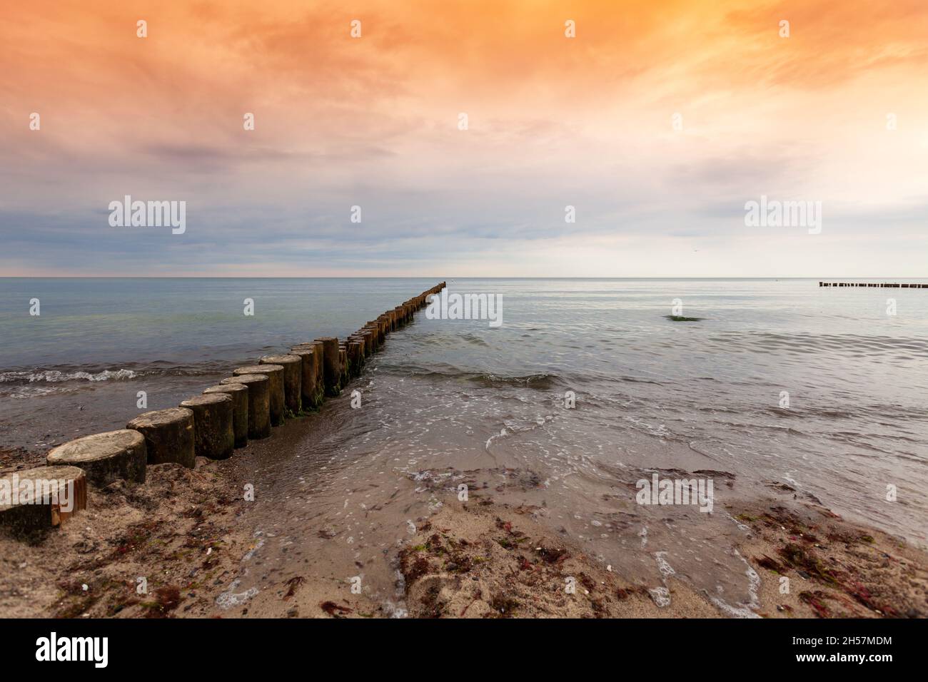 Wooden dock in the ocean. Colorful sky in the summer. Stock Photo