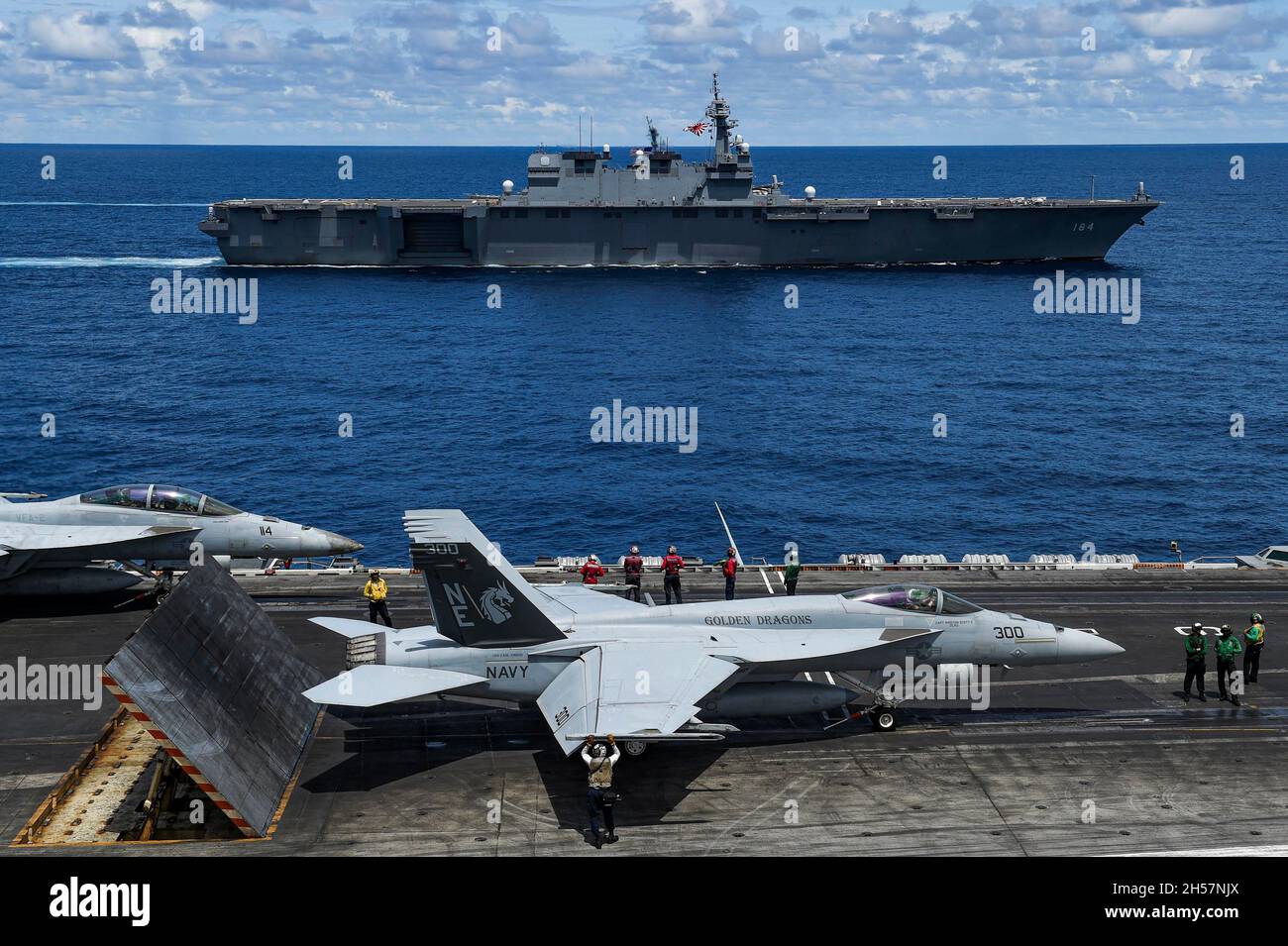 South China Sea, United States. 30 October, 2021. A U.S. Navy F/A-18 fighter jet prepares to launch from rom the flight deck of the Nimitz-class aircraft carrier USS Carl Vinson as the Japan Maritime Self- Defense Force Izumo-class helicopter destroyer JS Kaga sails alongside during joint operations October 30, 2021 in the South China Sea.  Credit: MC3 Tyler Wheaton/U.S. Navy/Alamy Live News Stock Photo