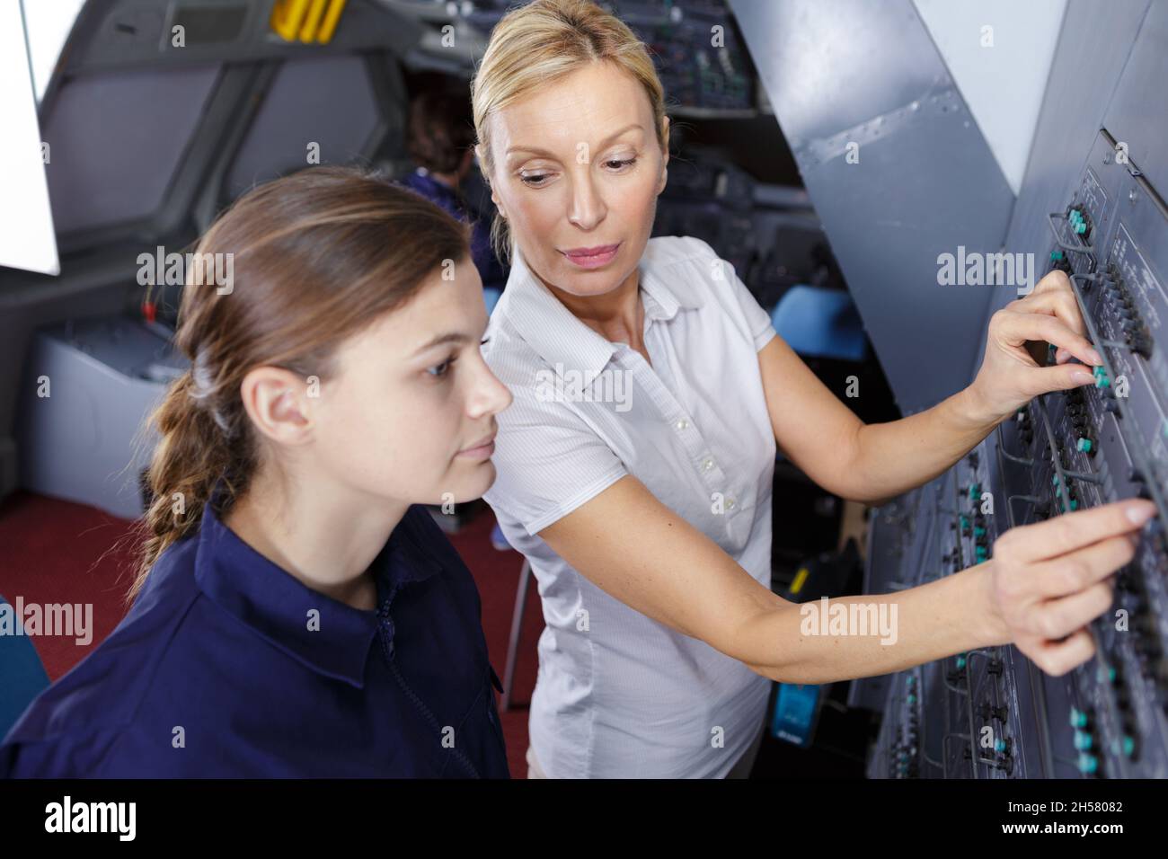 female aero engineer working on helicopter in hangar Stock Photo