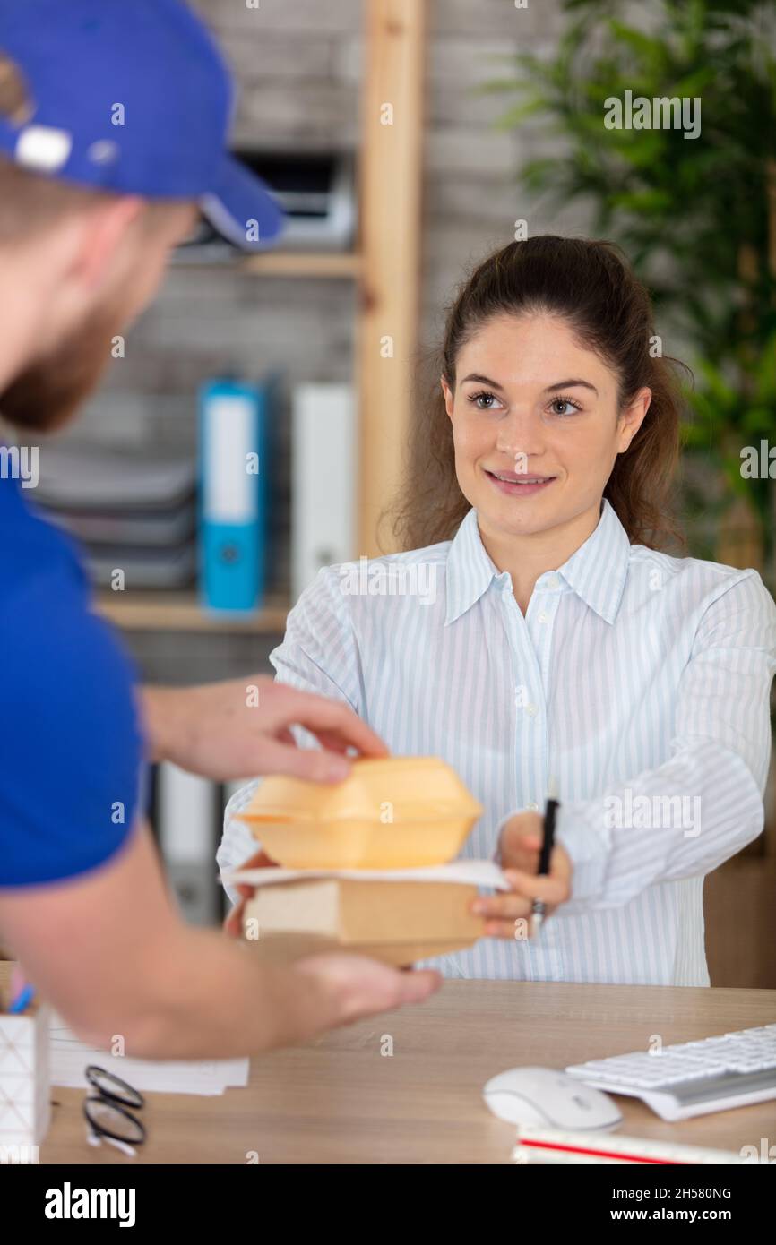 attractive young woman receiving fast food during office lunch break