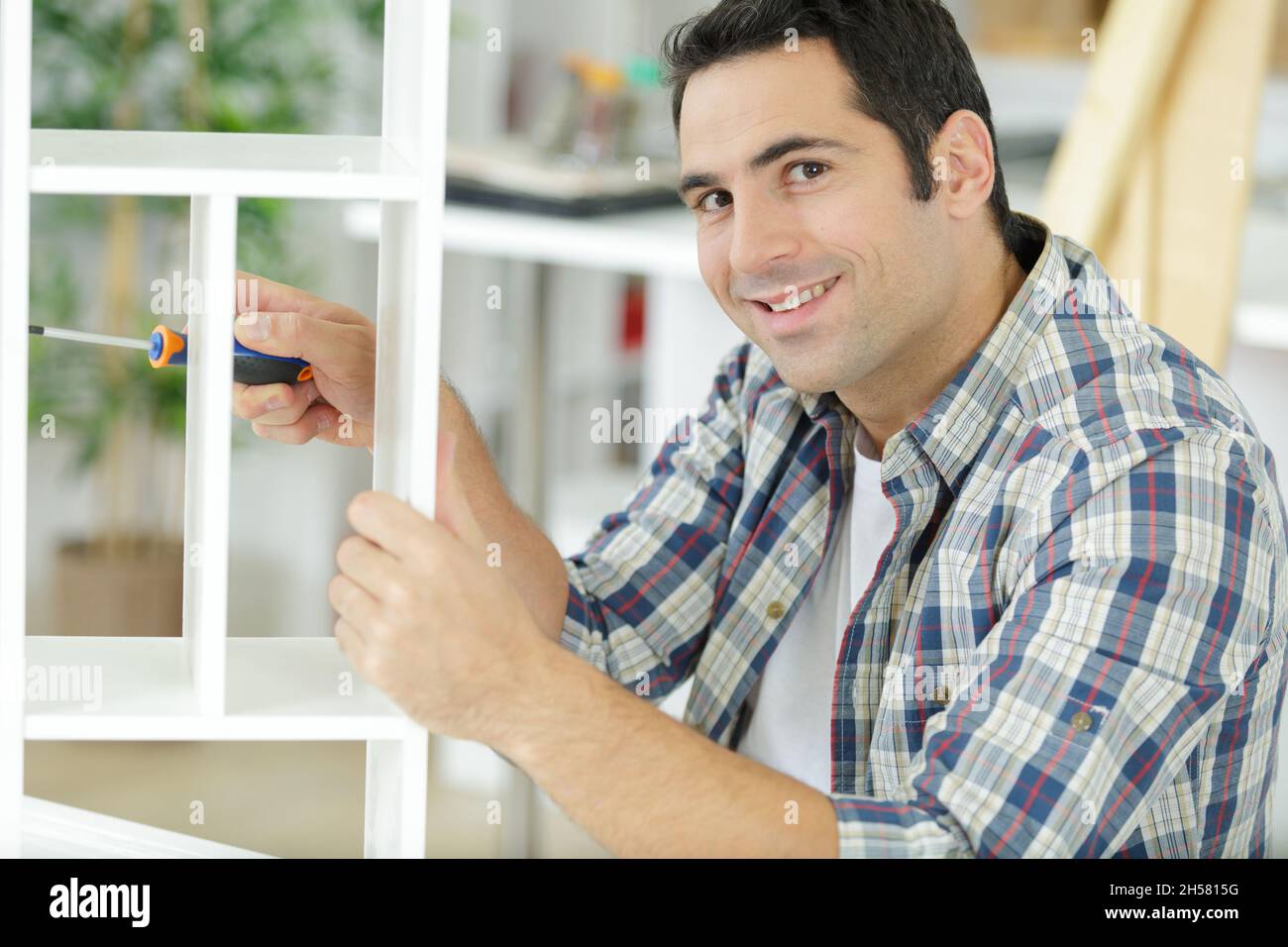 a satisfied carpenter tightening screws Stock Photo