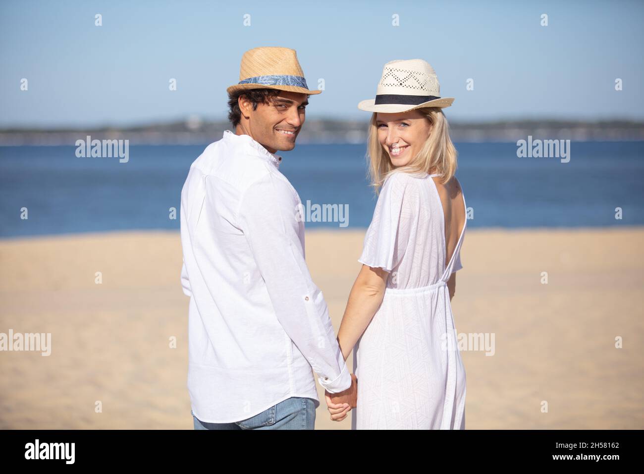 happy romantic couple on the beach holding hands Stock Photo - Alamy