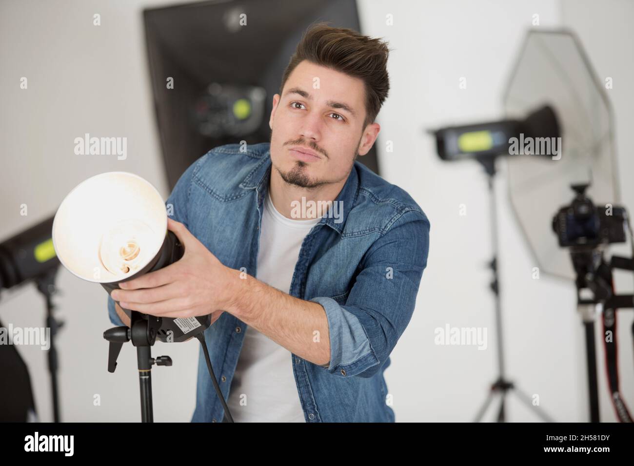 photographer before shooting model in studio with softboxes Stock Photo