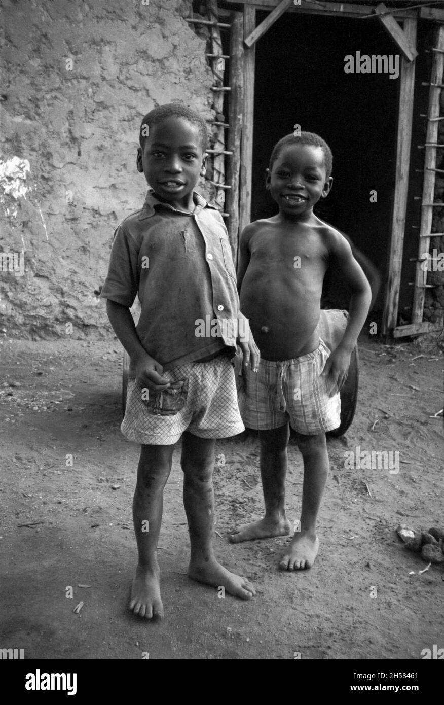 Africa, Tanzania, 1976. Ujamaa village Maasai people still live in their traditional homes. Two poor small boys with extended stomachs. Stock Photo