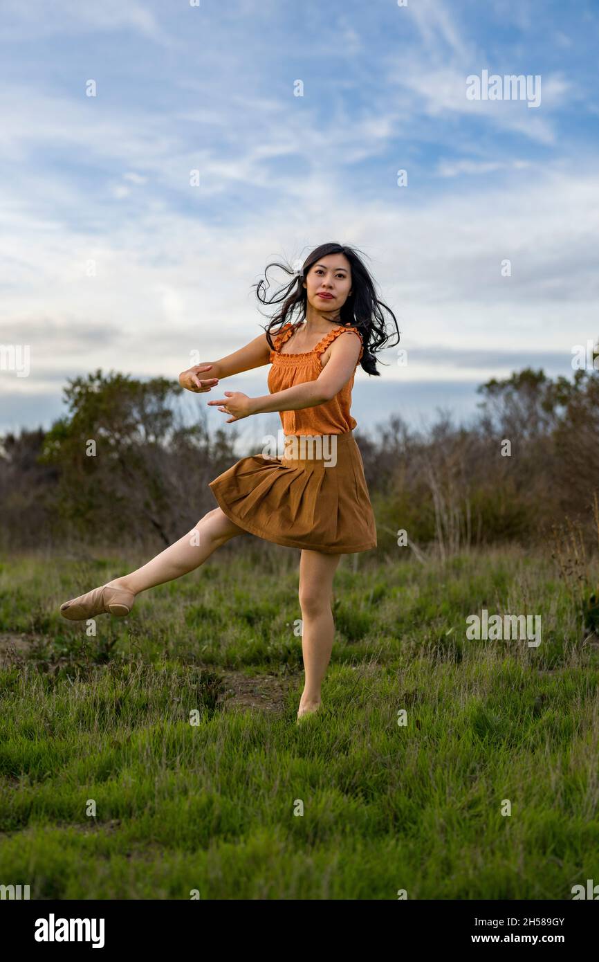 Woman in a Dress Doing Ballet Poses in the Marshlands Stock Photo