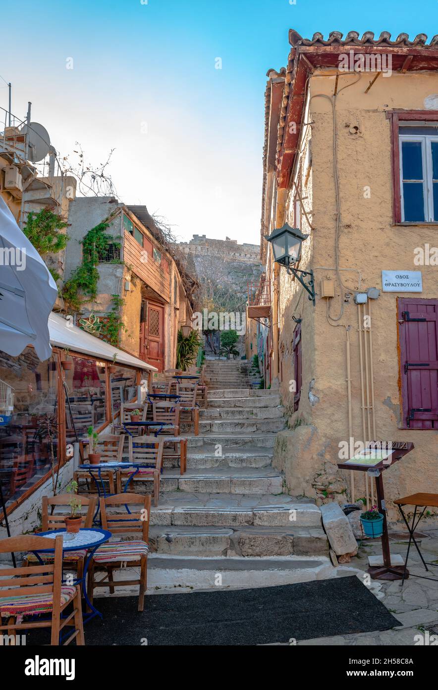 Sidewalk cafe in Plaka district, clustered around slopes of the Acropolis, with labyrinthine streets and neoclassical architecture. Athens, Greece. Stock Photo