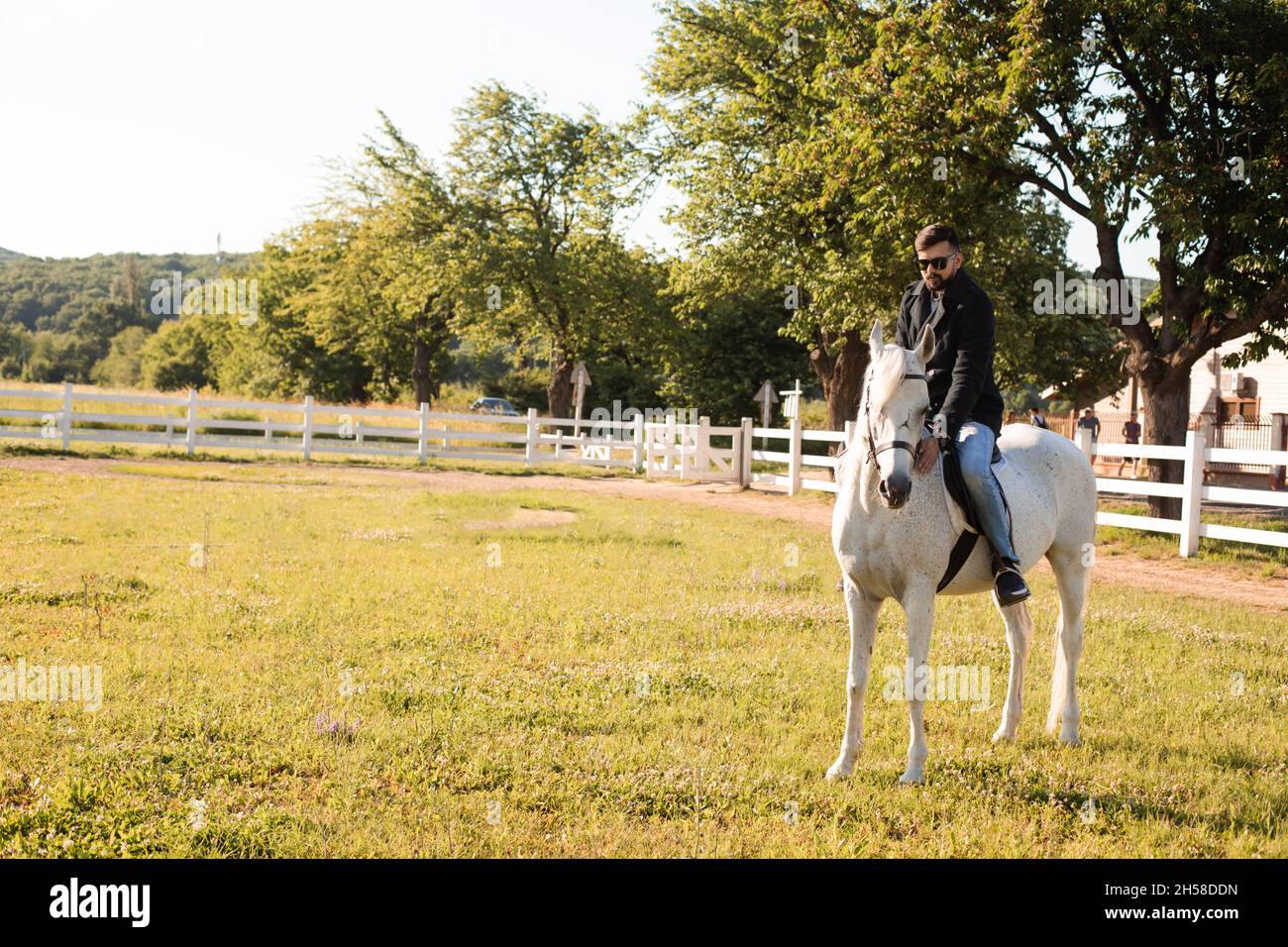 The young man is riding a horse on a farm Stock Photo - Alamy