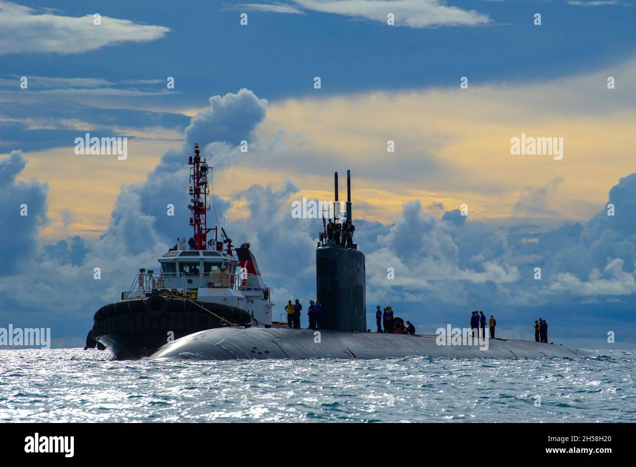 Saipan, United States. 21 October, 2021. The U.S. Navy Los Angeles-class fast attack submarine USS Hampton is assisted by a tug boat to moor at the submarine tender USS Frank Cable for resupply October 21, 2021 in Saipan, Northern Mariana Islands.  Credit: MC2 Chase Stephens/U.S. Navy/Alamy Live News Stock Photo