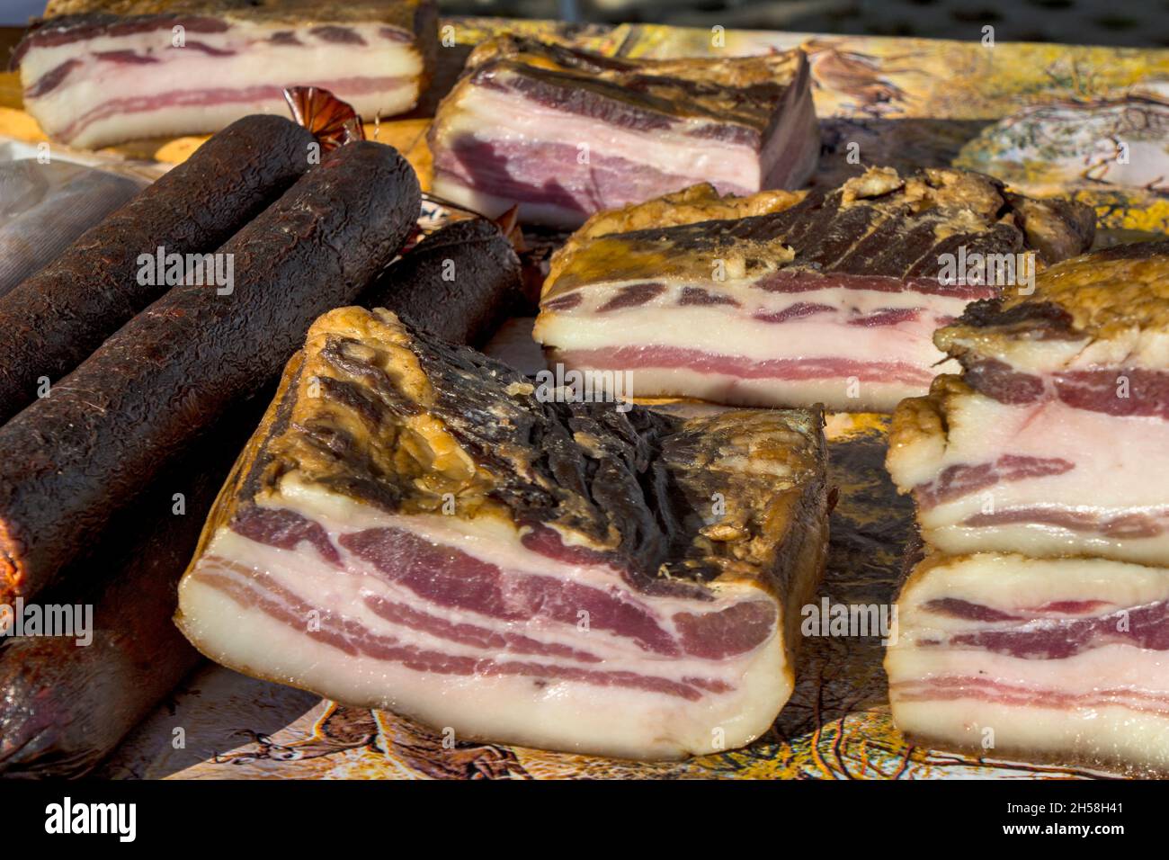 Exposed bacon and dried meat products. The products are domestic and are presented for sale. Stock Photo