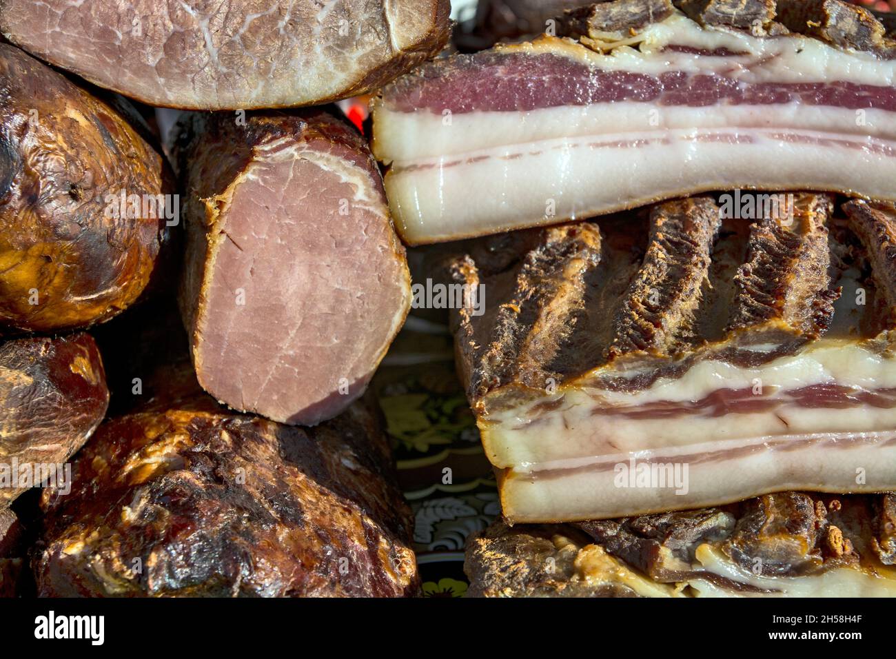 Exposed bacon and dried meat products. The products are domestic and are presented for sale. Stock Photo