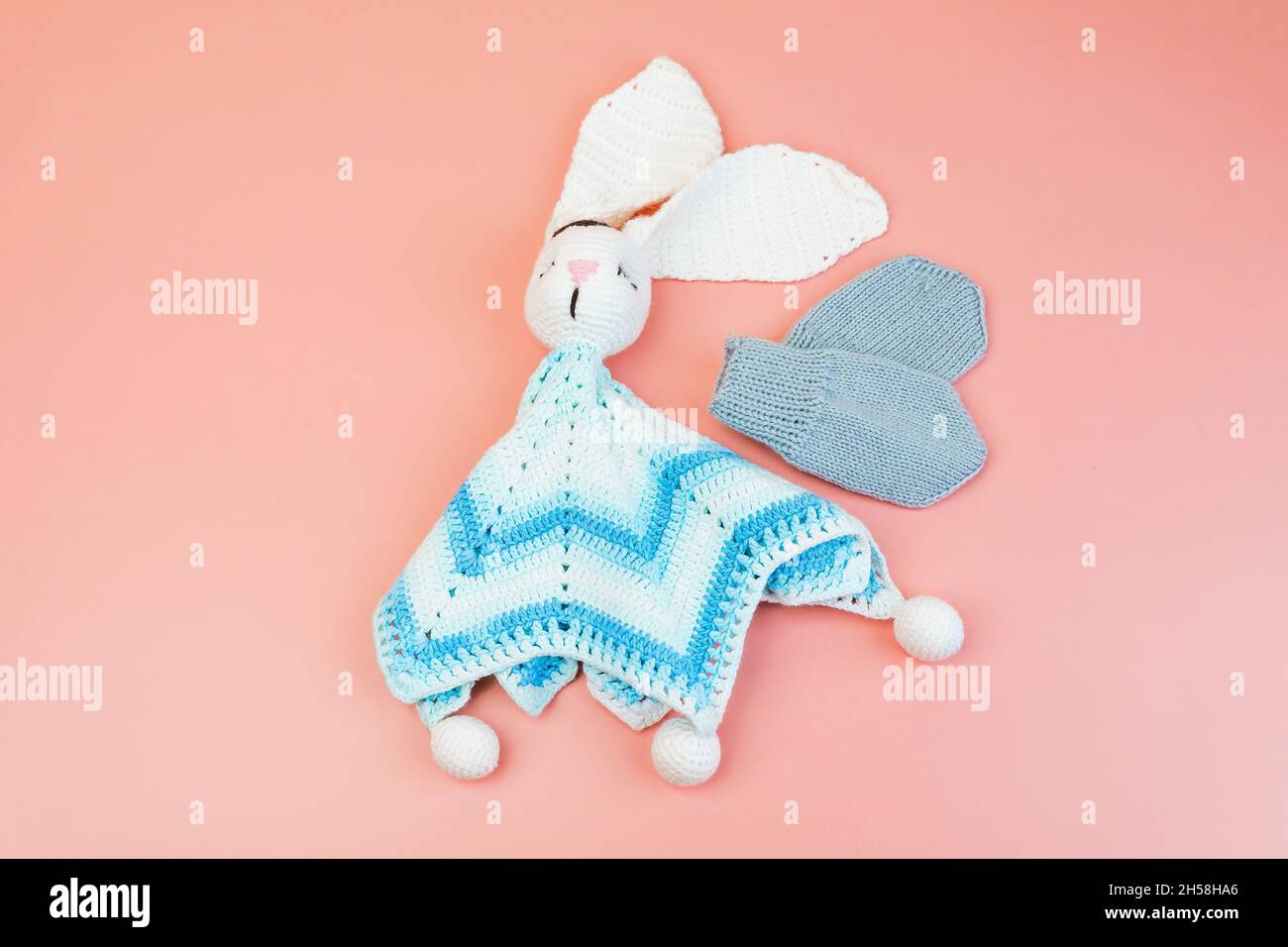 Handmade knitted blue and white bunny toy and grey mittens for