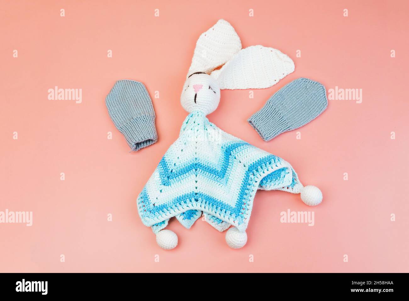 Handmade knitted blue and white bunny toy and grey mittens for