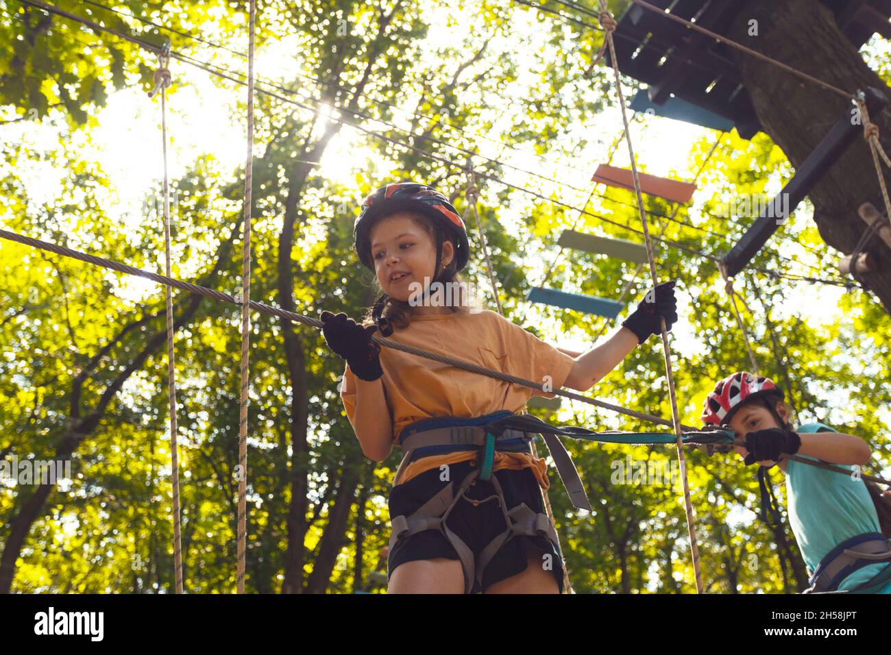 The concentrated kids are climbing in the high rope park Stock Photo