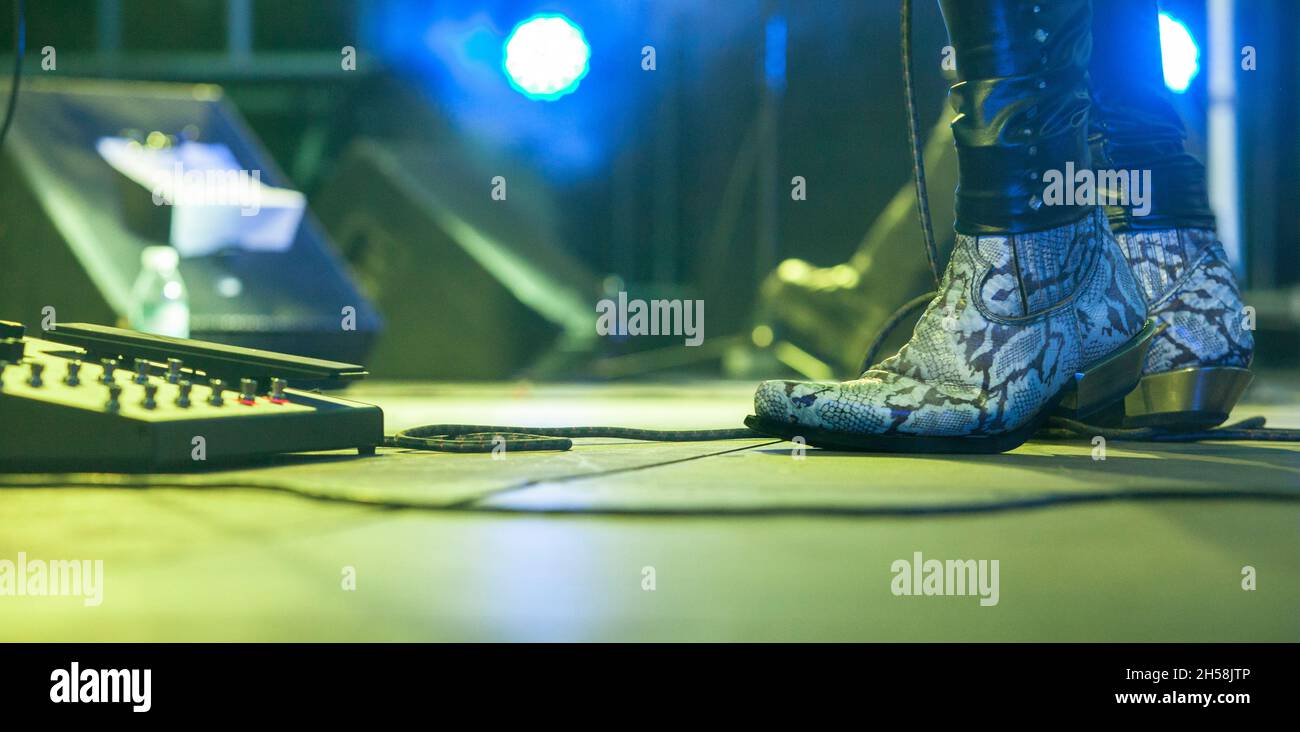 Hard rock musicians performing. Guitarist pedal effects Stock Photo