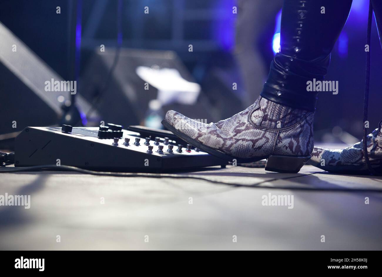 Rock guitarist playing with pedalboard. Hard rock musicians performing. Stock Photo