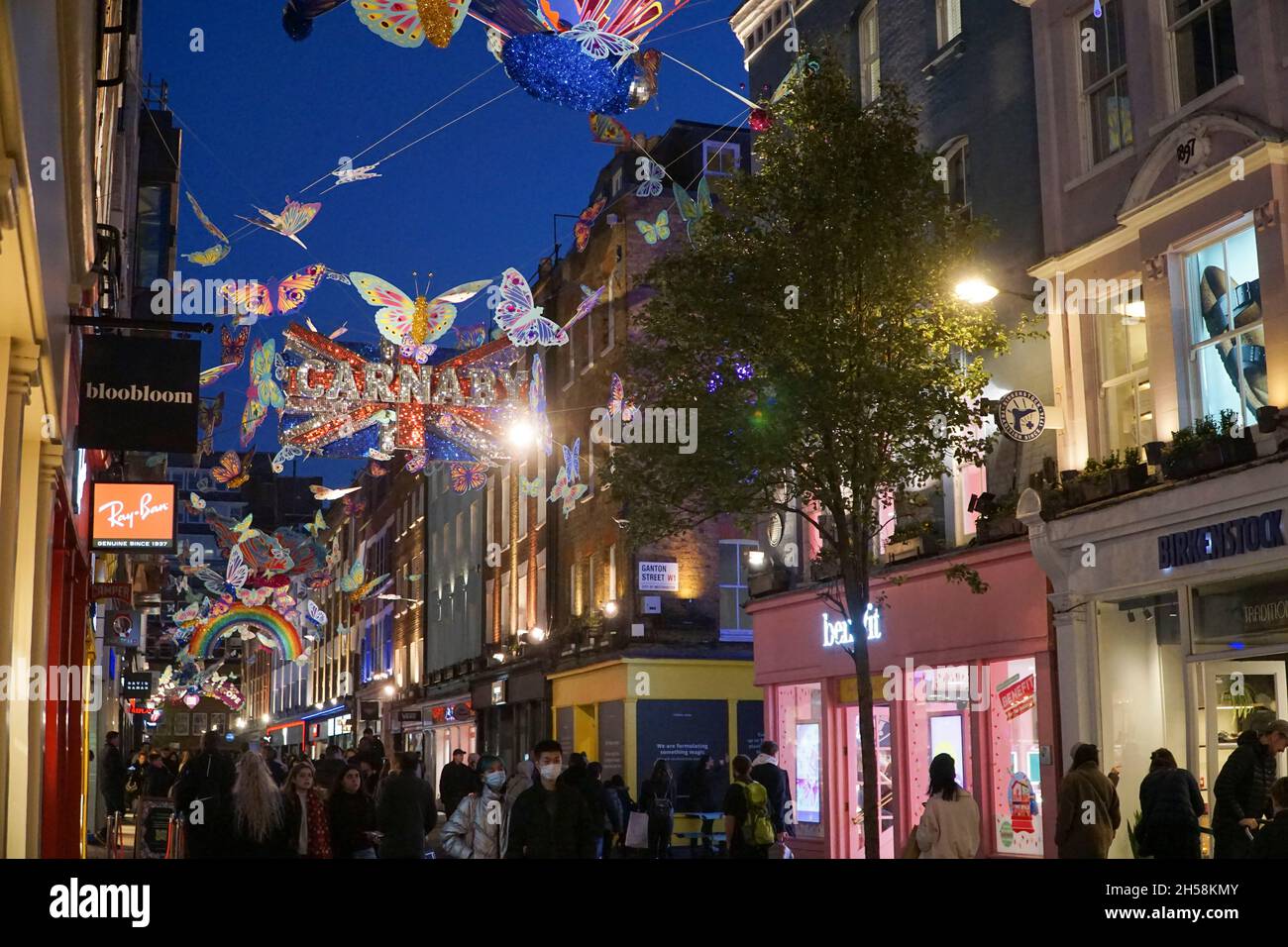 London, UK, 7 November 2021: On Sunday afternoon London's West End is full  of shoppers taking advantage of the dry weather to go shopping. The  Christmas lights above Carnaby Street feature multicolour